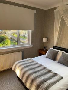 Un dormitorio con una cama grande y una ventana en West Park Hotel, en Clydebank
