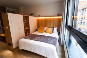 a bedroom with a bed and a large window at Studios Cielo Madrid in Madrid