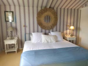 um quarto com uma cama e um espelho na parede em Ursuia Zazpi Au coeur du Golf d'Arcangues em Arcangues