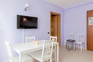 un comedor blanco con una mesa y sillas blancas en Chill House, en Livorno