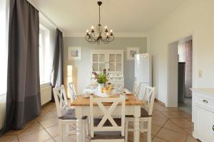 a kitchen and dining room with a white table and chairs at Ferienhaus für 8 Personen mit Kamin & Terrasse in Boltenhagen