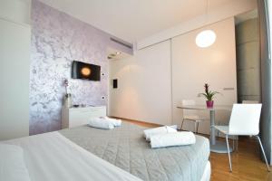 a bedroom with a large white bed and a table at Hotel Mantova Residence in Mantova +48 photos