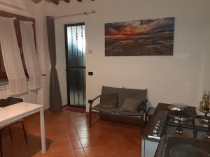 - une cuisine avec un canapé, une table et une cuisinière dans l'établissement La casa in giardino, à Volterra