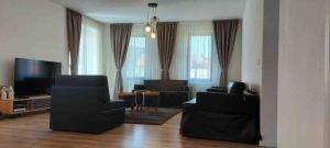 a living room with black furniture and a flat screen tv at Eco familia in Pojoga