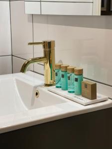 a sink with three bottles of toothpaste on it at Killeröd Boutique Apartments in Båstad