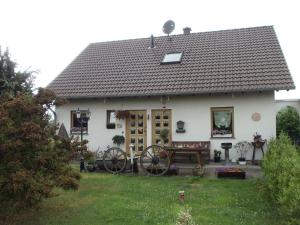 ein weißes Haus mit einer Bank im Hof in der Unterkunft Gästehaus Katharina in Müllenbach