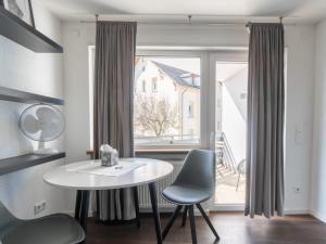 een kamer met een tafel en stoelen en een raam bij limehome Montabaur Kirchstraße in Montabaur