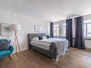 sypialnia z łóżkiem i niebieskim krzesłem w obiekcie limehome Montabaur Kirchstraße w mieście Montabaur