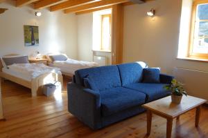 a living room with a blue couch and a bed at Agriturismo Maso Besleri in Cembra