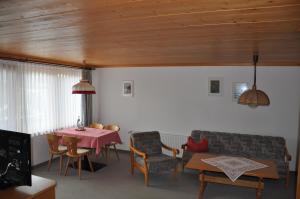 a living room with a table and a couch at Hotel Landhaus Schmid in Fischen