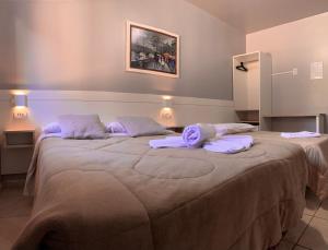 a bedroom with two beds with towels on them at Pousada Bello Outono in Canela