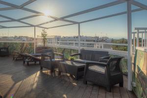 un patio con sillas y mesas en un balcón en Las Cebras Apartamentos Turísticos en Benicarló