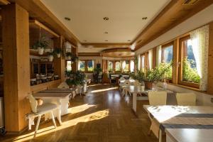 um restaurante com mesas, cadeiras e janelas em Berghotel und Restaurant Kräuter Chalet em Furtwangen