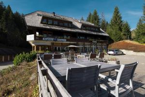 um restaurante com mesa e cadeiras em frente a um edifício em Berghotel und Restaurant Kräuter Chalet em Furtwangen