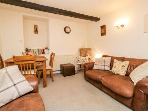 a living room with a couch and a table at Beckfold Cottage in Broughton in Furness