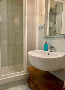 uma casa de banho branca com um lavatório e uma banheira em San Giovanni Garden House em Roma