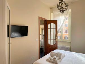 um quarto com uma cama e uma televisão na parede em San Giovanni Garden House em Roma