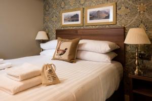 a bedroom with a bed with towels on it at The Pheasant Inn - The Inn Collection Group in Bassenthwaite