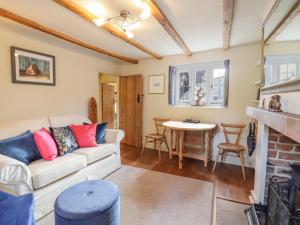 een woonkamer met een bank en een tafel bij Wayside Cottage in Bedford