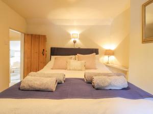 a bedroom with a large bed with two pillows at Wayside Cottage in Bedford