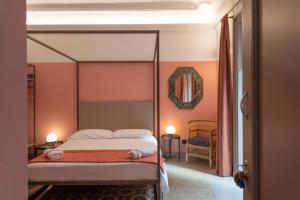 una camera da letto con un letto e uno specchio a parete di Palazzo Scammacca a Catania