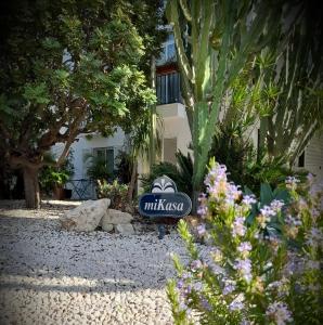 a sign in the middle of a garden with flowers at miKasa Agua Amarga & SPA in Agua Amarga