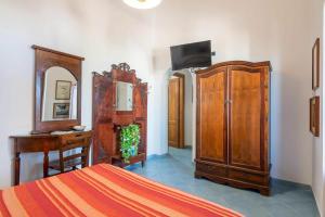 a bedroom with a bed and a desk and a dresser at Villa Artemis by Isula in Lipari