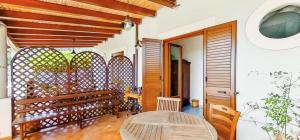 a porch with a wooden bench and a table at Villa Artemis by Isula in Lipari