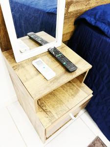 a table with two remote controls and a mirror at Aeroporto House 4 in Macapá +5 photos