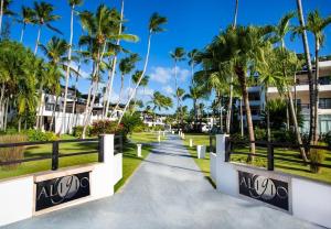 a walkway in front of a resort with palm trees at ALIGIO luxury apart-hotel in Las Terrenas