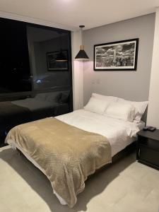 een slaapkamer met een groot wit bed en een raam bij Cómodo apartamento con excelente ubicación in Armenia