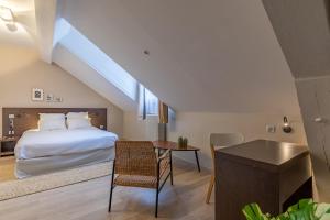 a bedroom with a bed and a table and a desk at 1924 Hôtel in Grenoble