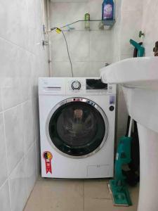 a washing machine in a bathroom next to a sink at Apartamento Inteiro com Vista do Lago Quitandinha in Petrópolis