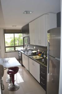 uma cozinha com um frigorífico de aço inoxidável e um lavatório em Apartamento Inteiro com Vista do Lago Quitandinha em Petrópolis