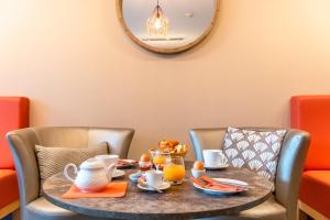 una mesa con una bandeja de comida para el desayuno. en Hôtel L'Empreinte, en Cagnes-sur-Mer