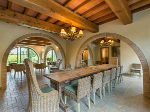 een eetkamer met een grote houten tafel en stoelen bij Villa Popillo in Montaione