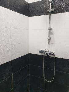 a shower in a bathroom with black and white tiles at GHALI House in Fez