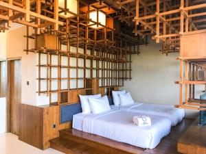 two beds in a room with a loft at HALO Sustainable Resort Karimunjawa in Karimunjawa