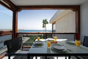a dining table with a view of the ocean at Apartamentos Los Papagayos in San Agustin
