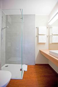 a bathroom with a glass shower and a sink at Sebcity Hotel in Ellwangen