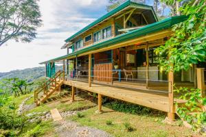 a house on a hill with a large porch at Edge of the World in Dominical