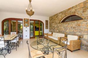 a dining room with a stone wall and a table and chairs at Private Luxury Villa with Pool in Moniga