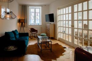 a living room with a blue couch and a tv at Boutique Hotel U zvonku in Třeboň