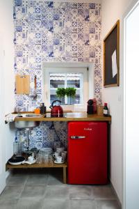 a red refrigerator in a kitchen with blue and white wallpaper at Boutique Hotel U zvonku in Třeboň