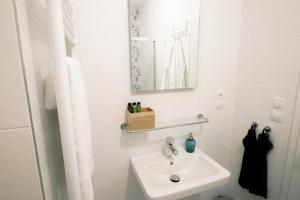 een witte badkamer met een wastafel en een spiegel bij Boutique Hotel U zvonku in Třeboň