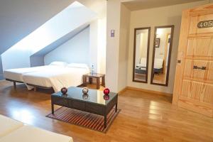 a bedroom with a bed and a table and a mirror at Hotel El Tratado in Tordesillas