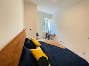 1 dormitorio con 1 cama grande con almohadas amarillas en Dagmar Apartment, en Bratislava