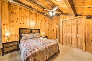 a bedroom with a bed in a room with wooden walls at All-Season Sanctuary Steps to Moosehead Lake in Greenville