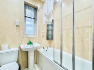 La salle de bains est pourvue de toilettes, d'un lavabo et d'une douche. dans l'établissement Millerston House, à Glasgow