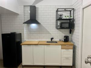 a kitchen with a sink and a black refrigerator at PUERTA DE CACERES Apartamento 2 in Cáceres